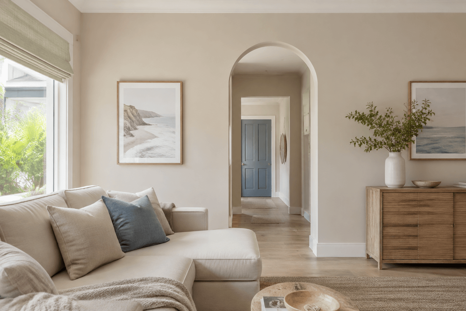 freshly painted sand-coloured living room with a curved doorway and oak furniture